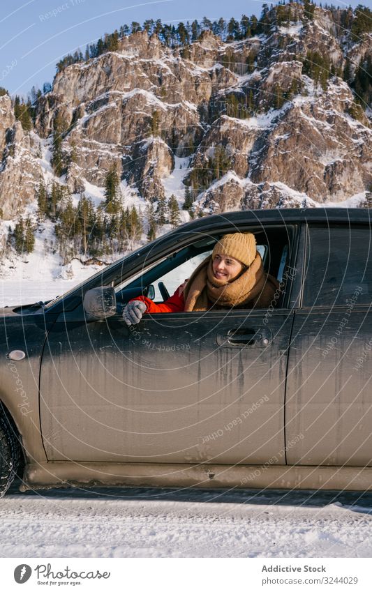 Frau lehnt sich aus dem Autofenster im verschneiten Tal PKW Fenster Berge u. Gebirge Winter Sibirien Autoreise Glück genießen Lächeln Natur Landschaft Felsen