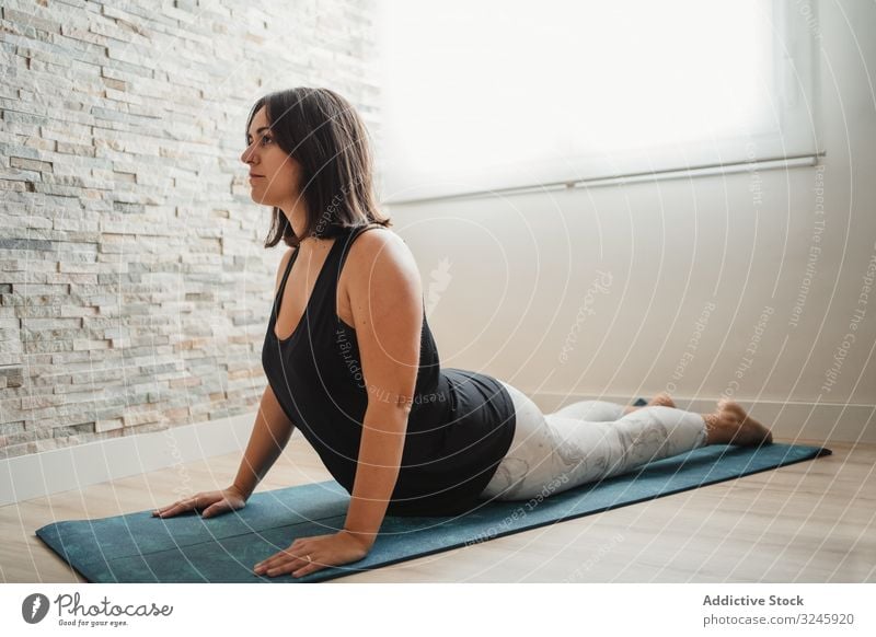 Frau meditiert zu Hause Meditation Yoga heimwärts Pose Unterlage praktizieren Morgen Raum Erholung jung brünett Wellness passen Gesundheit Windstille Zen