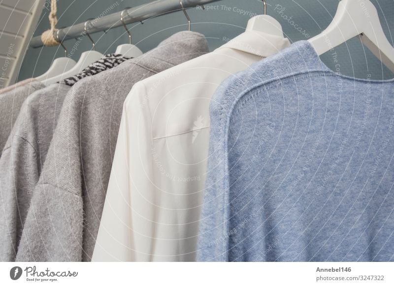 Die Kleidung hängt an einem Kleiderständer, weiß, grau und blau, kaufen Stil Sommer Business Frau Erwachsene Mode Bekleidung T-Shirt Hemd Jacke Stoff Sammlung