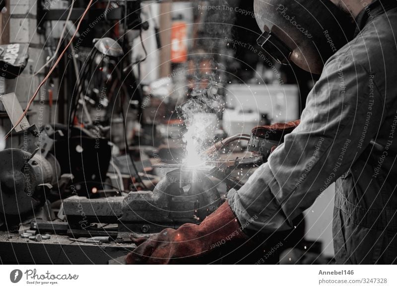 Schweißer schweißt Metallteil in der Garage. mit Schutzmaske, Arbeit & Erwerbstätigkeit Beruf Arbeitsplatz Fabrik Industrie Werkzeug Technik & Technologie Mann