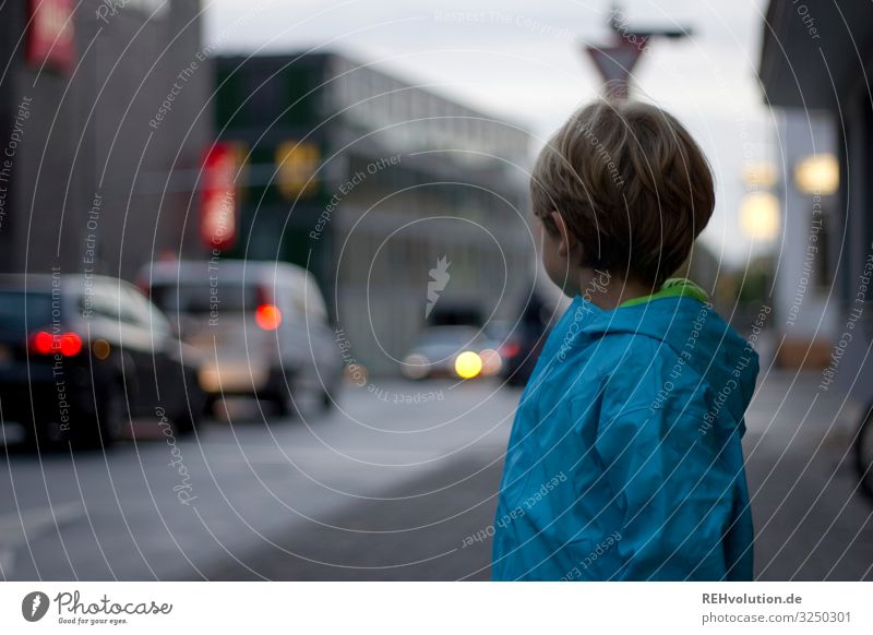Junge steht an der Straße trüb schlechtes Wetter lichter Licht Personenverkehr Verkehrsmittel Stadtzentrum Fahrzeug Straßenkreuzung Farbfoto Fußgänger