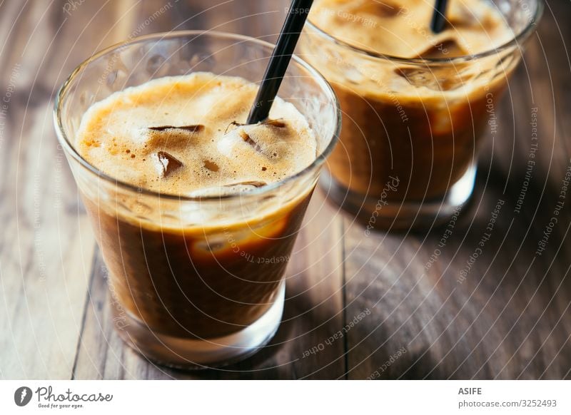 Gläser mit Eiskaffee-Latte Dessert Getränk Kaffee Sommer Tisch Restaurant Holz dunkel frisch lecker braun eisbedeckt melken Milchshake kalt Glas Eiswürfel Stroh