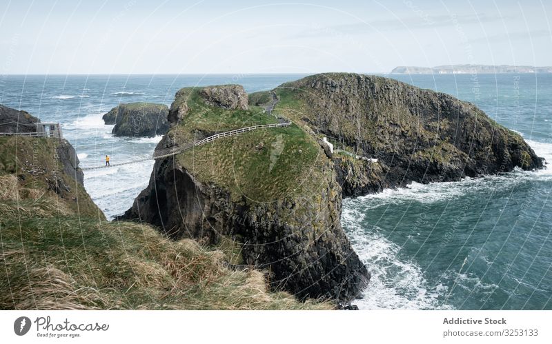 Touristen wandern auf einer Seilbrücke zwischen den Klippen in Nordirland Brücke Felsen MEER Spaziergang Meer Person durchkreuzen Küste Ufer Wasser Landschaft