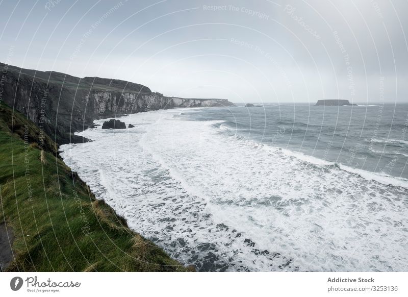 Nordirlands Küstenlinie mit Wellen winken Meer Meereslandschaft stürmisch wolkig Felsen Gras MEER schäumen Landschaft Wetter kalt grau Saison Kraft Energie