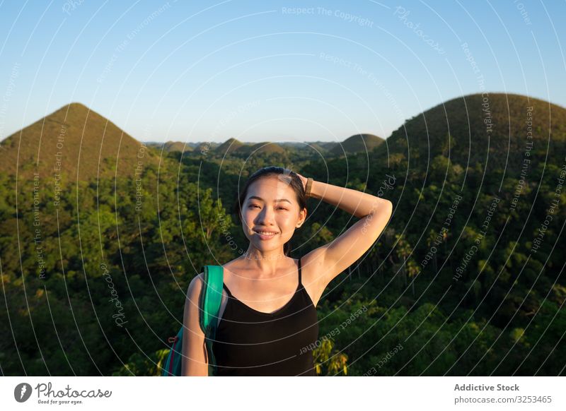 Glückliche Frau steht auf der Aussichtsplattform auf einem Hügel Zaun stehen jung Abenteuer Lächeln Tourist ethnisch asiatisch heiter freudig grün