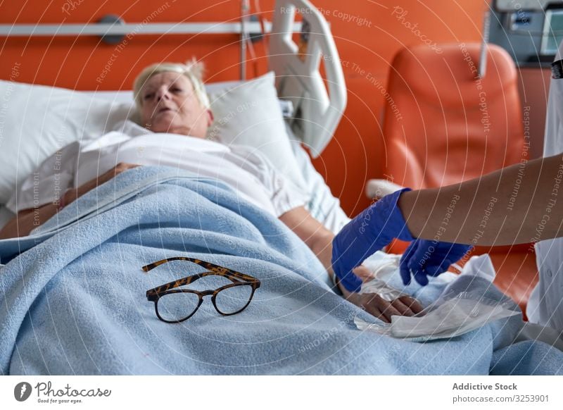 Pflanzenpflegerin injiziert Medikamente in den Arm eines reifen Patienten Krankenpfleger geduldig Einspritzung Medizin Station Krankenhaus Katheter älter
