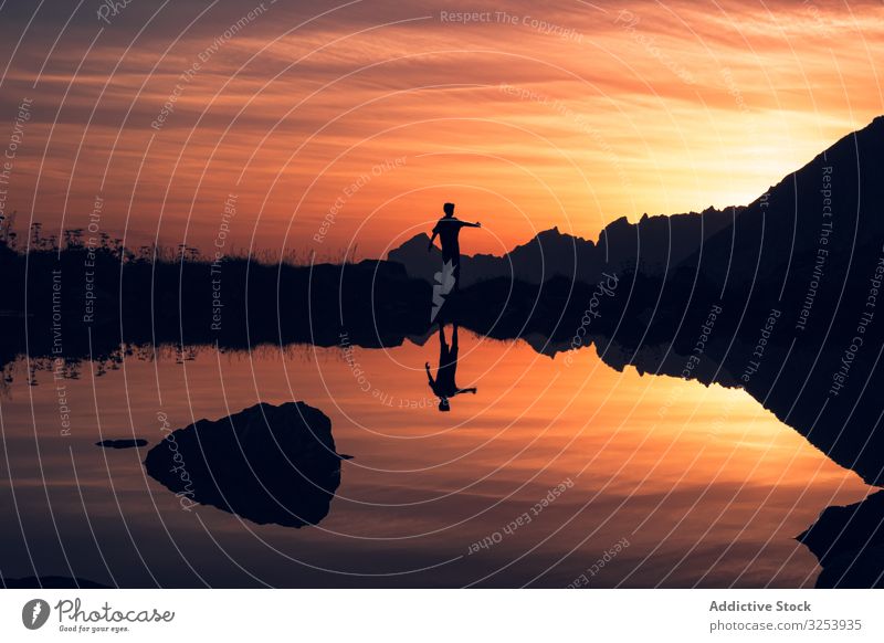 Am Ufer stehende Person, die sich im Wasser spiegelt Silhouette See Berge u. Gebirge Reflexion & Spiegelung malerisch ruhig Seeküste Stein Sonnenuntergang