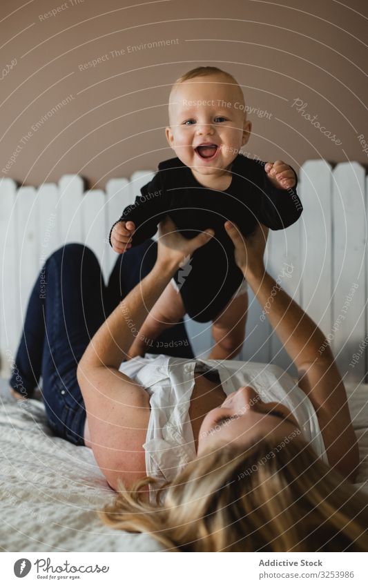 Mutter spielt mit Baby im Bett spielen aufgeregt heimwärts heben Pflege Familie Frau Kind Kinderzimmer Spaß Bonden Unschuld Glück Freude heiter erfreut