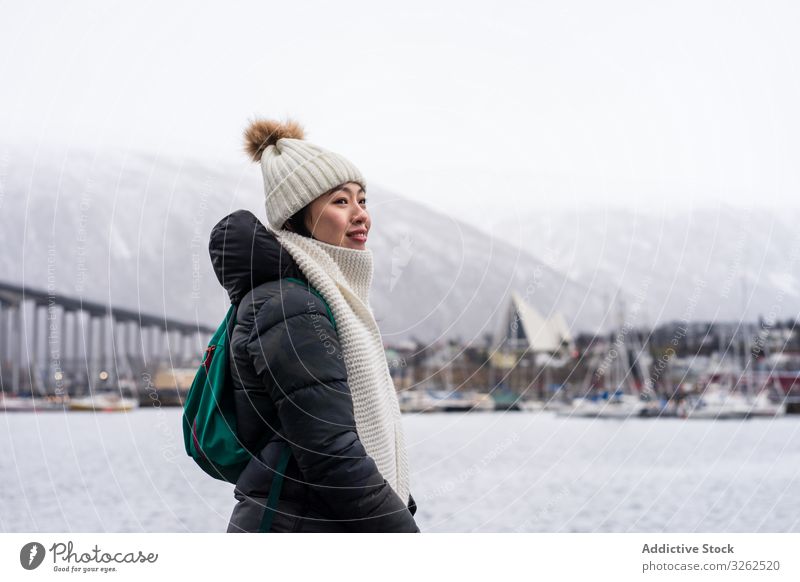 Asiatische Touristin in warmer Kleidung auf verschneitem Feld nahe der Stadt Tourismus laufen Winter Großstadt Frau Bekleidung reisen Schnee Gebäude Feiertag