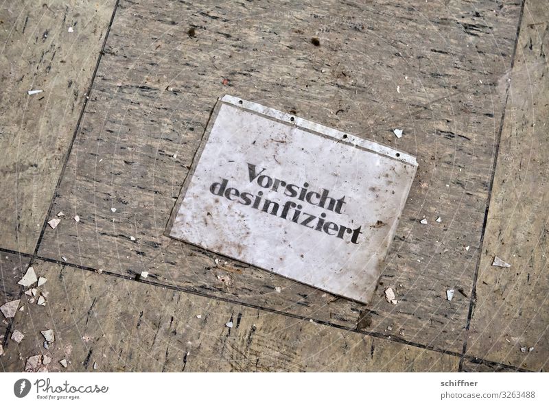 Lüge Schriftzeichen Hinweisschild Warnschild dreckig Bodenbelag Bodenplatten bodennah Desinfektion Vorsicht Warnung lügen unlogisch Klarsichtfolie Müll seltsam