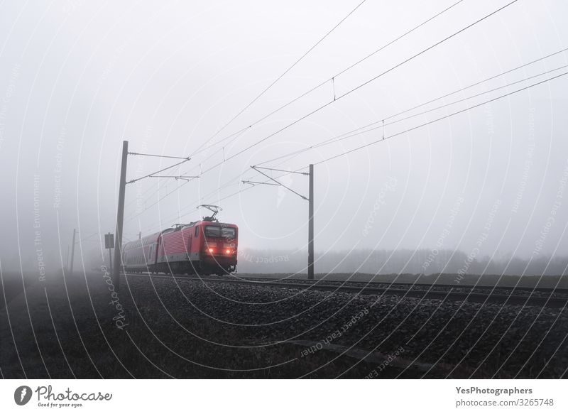 Rote Zuglokomotive durch Nebel, der sich auf Eisenbahngleisen bewegt. Ferien & Urlaub & Reisen Ausflug Winter Herbst schlechtes Wetter Verkehr