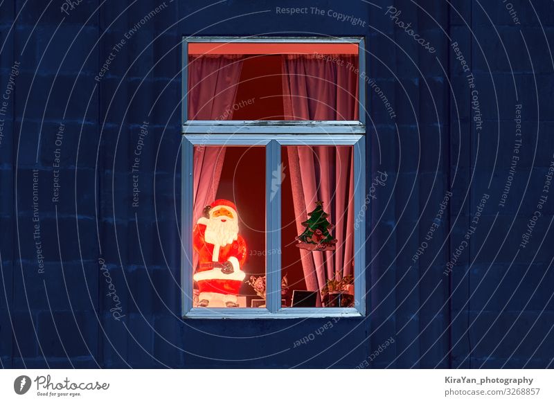 Fröhlich leuchtender illuminierter Weihnachtsmann in einem gemütlichen Fenster. Winter Wohnung Dekoration & Verzierung Lampe Feste & Feiern Weihnachten & Advent