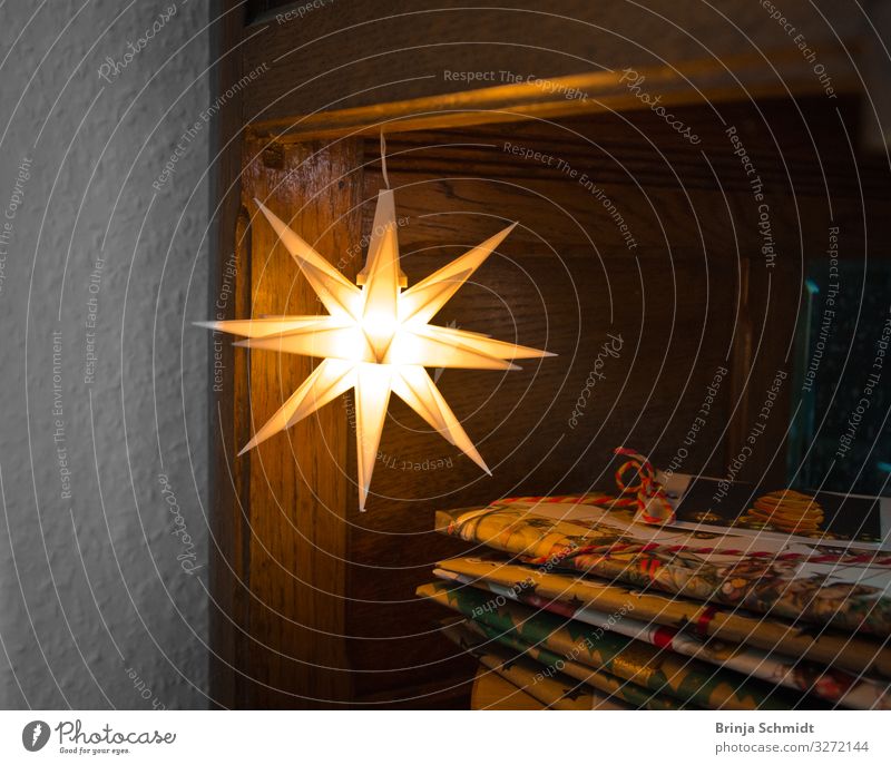 Ein kleiner leuchtender Stern hängt über Weihnachtsgeschenken Innenarchitektur Dekoration & Verzierung Lampe Weihnachten & Advent Licht Kerze Geschenk