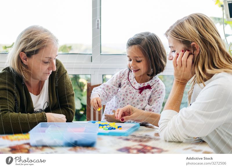 Frau spielt Brettspiel mit Tochter und Enkelin spielen Holzplatte Familie Spiel generationenübergreifend Mutter Töchter Zusammensein Spaß Glück Großmutter