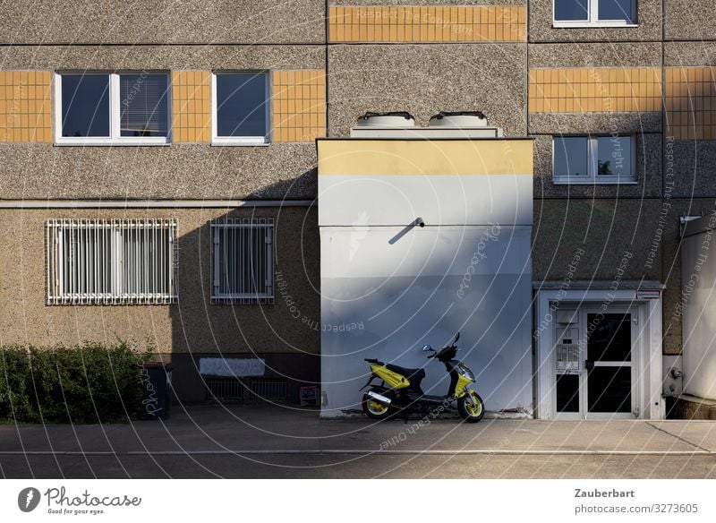 Plattenbau-Fassade mit gelbem Roller Berlin Stadt Menschenleer Haus Hochhaus Mauer Wand Fenster Tür Kleinmotorrad Stein Beton fahren Häusliches Leben eckig