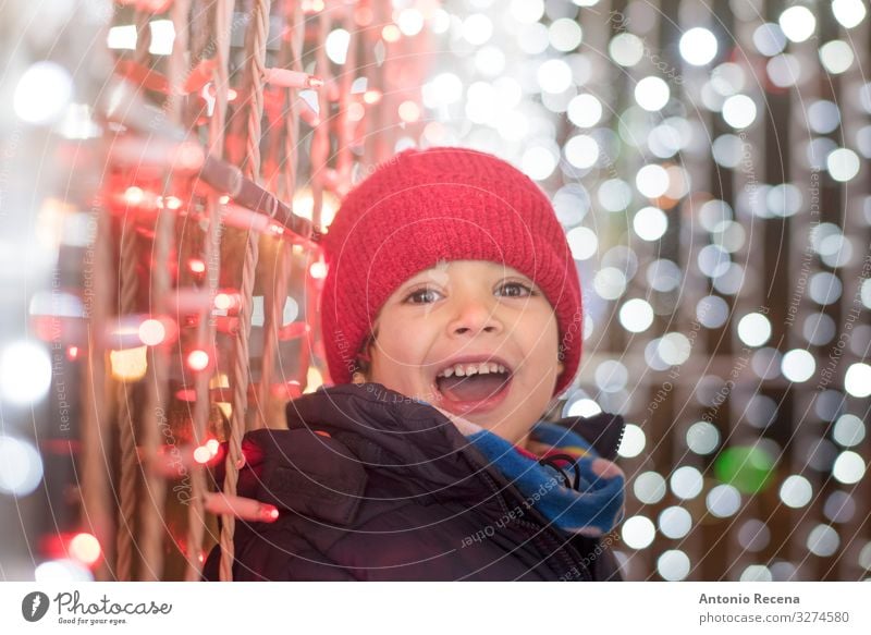 Lächelnder Junge in der Weihnachtsnacht mit Blick in die Kamera Freude Winter Feste & Feiern Kind Mensch Schal Hut weiß Gefühle Überraschung Weihnachten
