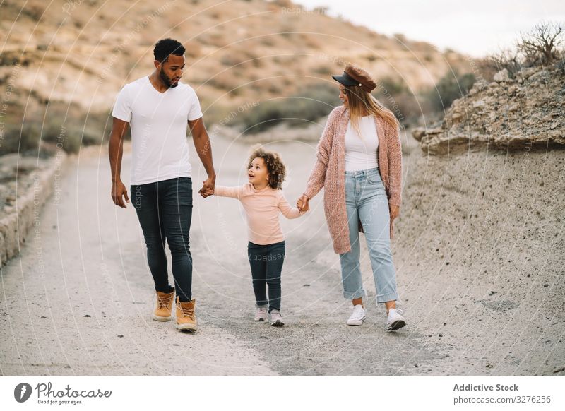 Stilvolle multiethnische Familie geht in der Natur spazieren Spaziergang Hand in Hand Zusammensein Eltern Kleinkind ruhen Lächeln Glück schlendern heiter
