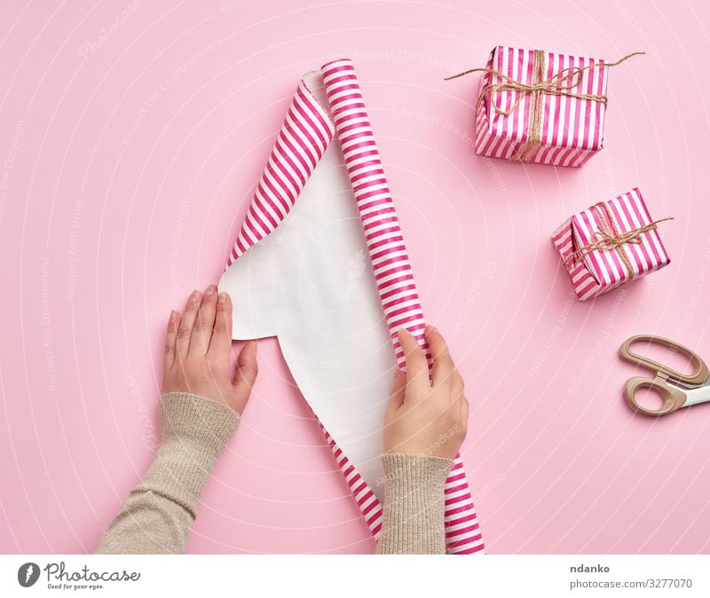 Frauenhände falten eine Rolle Geschenkpapier auf Design Winter Dekoration & Verzierung Feste & Feiern Weihnachten & Advent Silvester u. Neujahr Geburtstag Hand