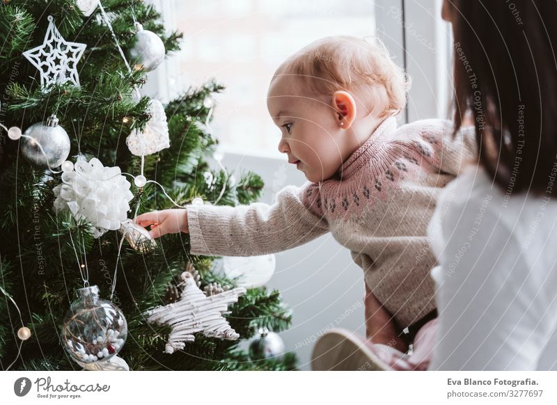 Kleines Mädchen hält goldenes Ornament vor einem Weihnachtsbaum - ein  lizenzfreies Stock Foto von Photocase