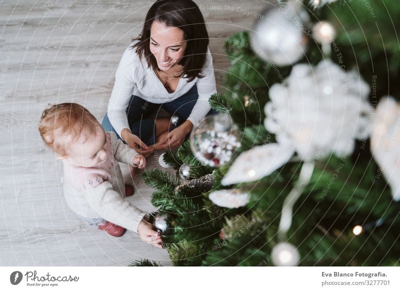 glückliche Mutter und Mädchen, die den Weihnachtsbaum schmücken Mutterschaft Glück niedlich Baby ein Jahr dekorierend Weihnachten & Advent Baum Freude