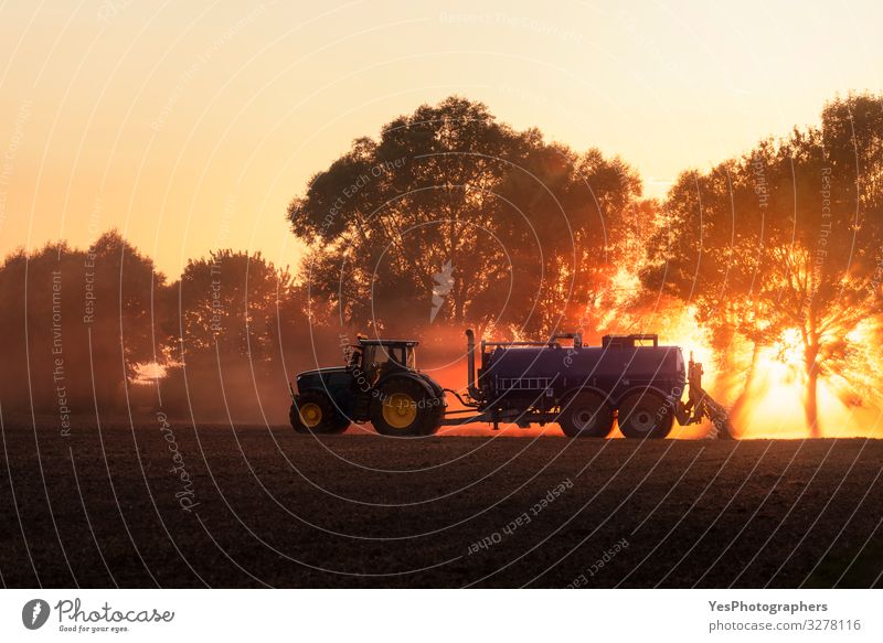 Traktor düngt landwirtschaftliches Feld bei Sonnenuntergang. Landwirtschaft Arbeit & Erwerbstätigkeit Beruf Natur Landschaft Erde orange Deutschland Aktion