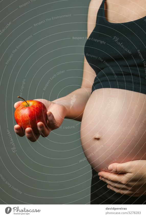 Schwangere Frau hält einen Apfel Frucht Ernährung Vegetarische Ernährung Diät Lifestyle schön Baby Erwachsene Eltern Mutter Familie & Verwandtschaft Hand Liebe