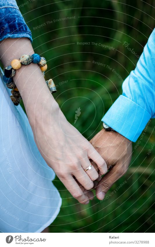 Ein Paar hält sich an der Hand mit Verlobungsring und Blauer Kleidung paar zusammen hand halten hochzeit leute frau braut ehepaar trauung aufstehen weiß liebe