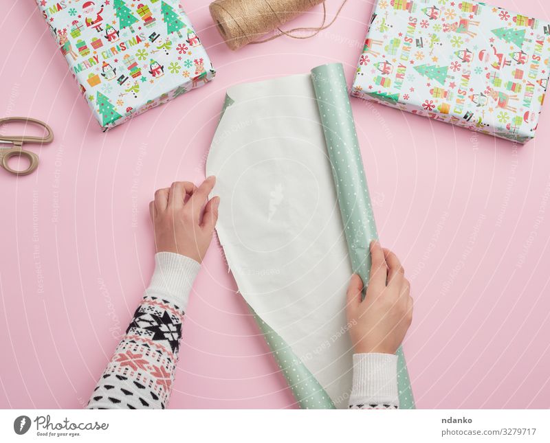 Frauenhände falten eine Rolle Geschenkpapier auf Lifestyle Design Winter Dekoration & Verzierung Feste & Feiern Weihnachten & Advent Geburtstag Erwachsene Hand
