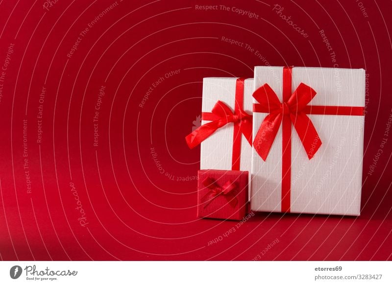 Sortierte weiße Geschenkverpackungen auf rotem Hintergrund. Leerzeichen kopieren Weihnachten & Advent Kasten Schleife Schnur Gegenwart Geburtstag