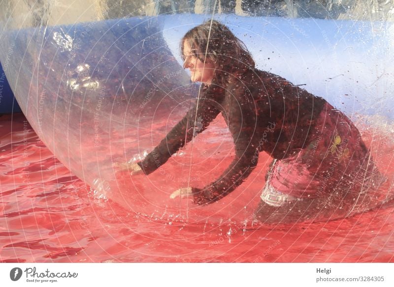 Frau kniet vergnügt in einer großen Plastikkugel im Wasserbecken Mensch feminin Erwachsene 1 45-60 Jahre Bekleidung T-Shirt Rock brünett langhaarig Bubble