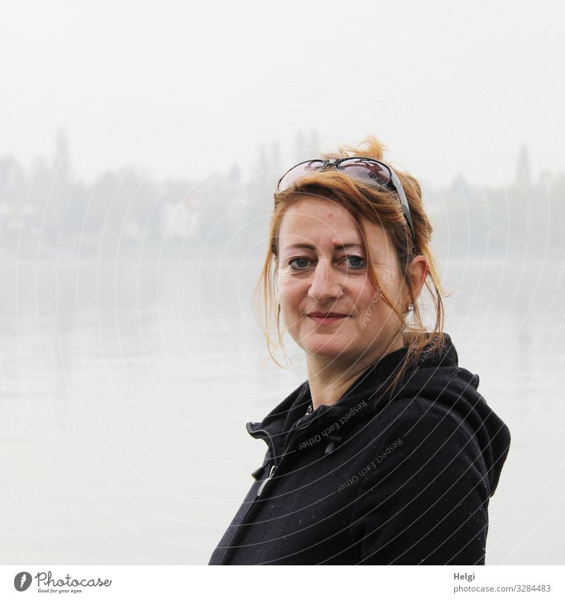 Porträt einer lächelnden Frau mit brünetten langen Haaren und dunkler Jacke  in Nebellandschaft Mensch feminin Erwachsene 1 45-60 Jahre See Bekleidung