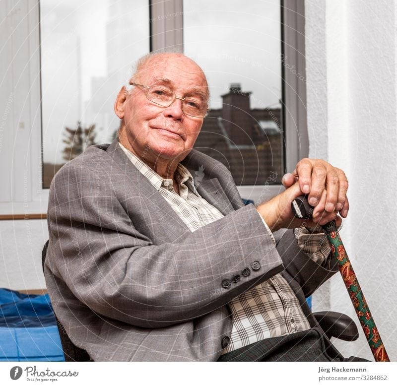 Ein lächelnder älterer Mann sitzt auf einem Stuhl und sieht glücklich aus Lifestyle Freude Glück Gesicht Erholung Windstille Ruhestand Mensch Erwachsene Jacke