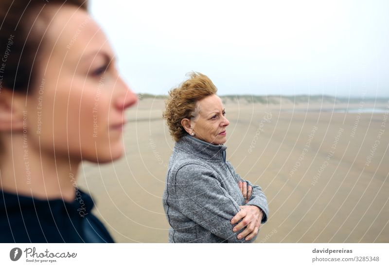Zwei Frauen mit Blick aufs Meer am Strand im Herbst Lifestyle schön Meditation Mensch Erwachsene Mutter Großmutter Familie & Verwandtschaft Sand Wind Nebel