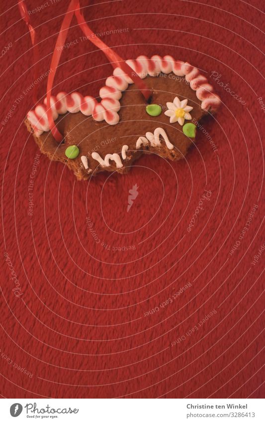 angebissenes Lebkuchenherz auf rotem Untergrund Lebensmittel Teigwaren Backwaren Lebkuchenherzen Ernährung Kitsch Krimskrams Souvenir Herz Fröhlichkeit trendy