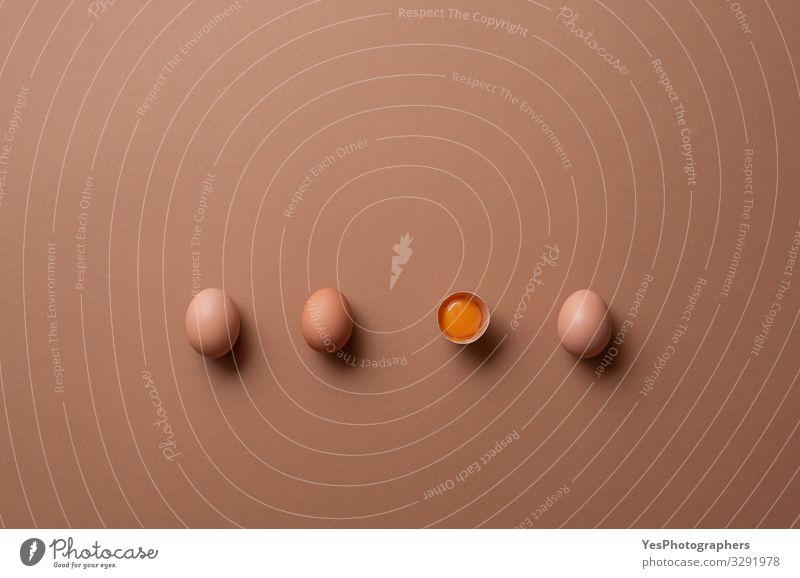 Bio-Eier und ein Knick-Ei mit Eigelb. Ausgerichtete Eier Ernährung Diät Gesunde Ernährung frisch natürlich obere Ansicht ausgerichtet brauner Hintergrund
