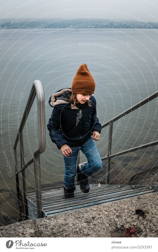 Junge am See im Winter Kind Zürich See Treppe Wasser Mütze winterjacke Bewegung Außenaufnahme Farbfoto Tag Natur kalt blau Landschaft Schweiz Menschenleer