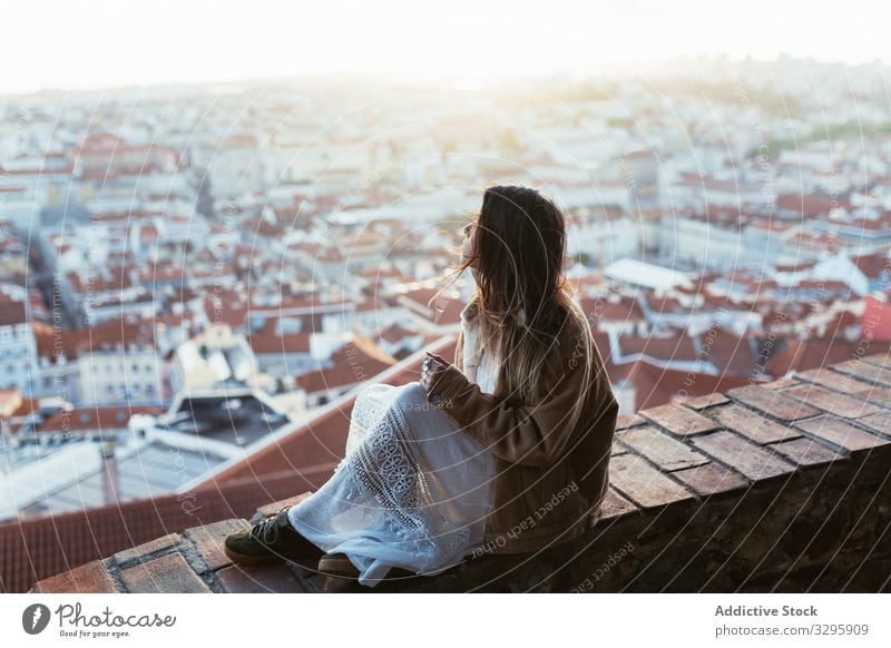 Verträumte Frau sitzt an der Grenze nahe der Stadt Morgen Borte sitzen ruhen sonnig jung verträumt bewundern Portugal Stadtbild Großstadt Wochenende Barriere