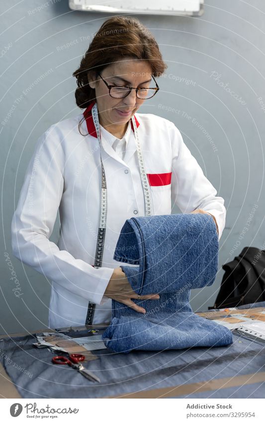 Arbeitende Frau bei der Kontrolle von Textilfabriken Industrie Fabrik Bekleidung Herstellung Arbeiter Maschine Nähen Hände Gewebe Hose Blue Jeans Beruf