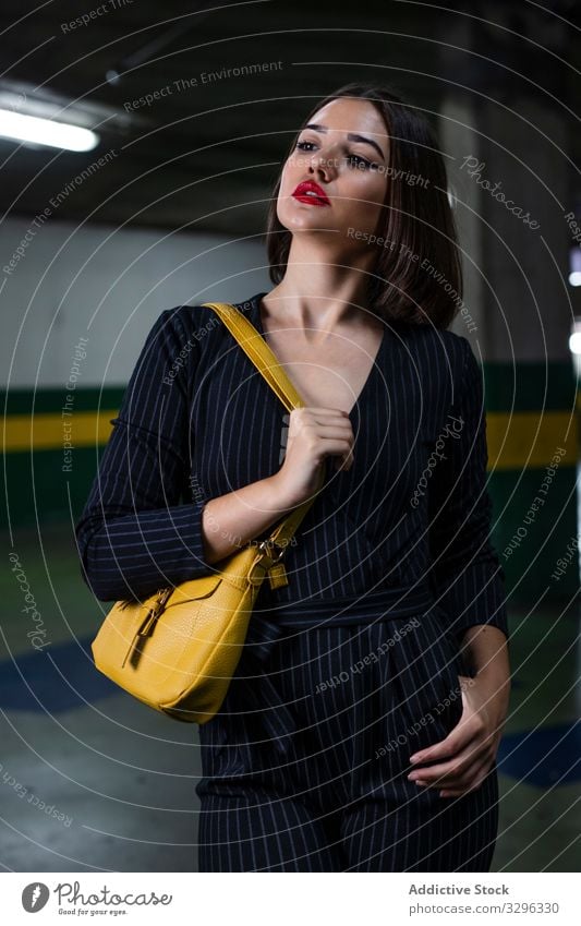 Frau in schickem Outfit auf einem Parkplatz modisch trendy Abenddämmerung Schatten stylisch Bekleidung Großstadt Straße Stehen jung Verschlussdeckel Dame