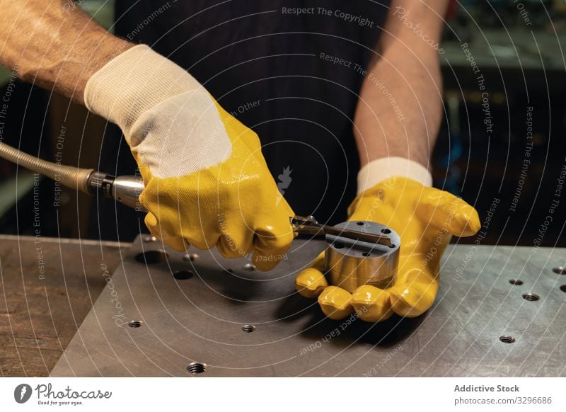 Gesichtsloser Vorarbeiter benutzt Ausrüstung in der Werkstatt Polier benutzend Gerät Mann Handschuhe prüfen vorbereiten Sicherheit Industrie Schutz männlich
