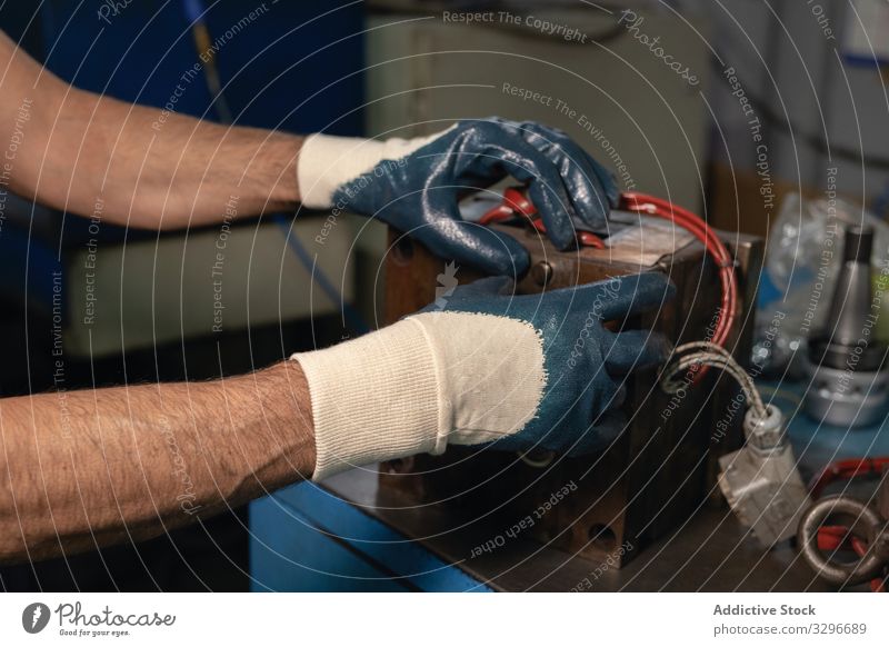 Mechanismus zum Zusammenbau der Erntehelfer in der Werkstatt Mann versammeln Maschine Hobelbank Handschuh Handwerk Industrie Arbeit Reparatur männlich