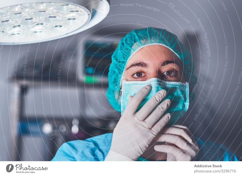 Weibliche Chirurgin im Operationssaal Krankenhaus Mundschutz Hut bereit Frau Arbeit Arzt Gesundheitswesen Job Uniform Medizin Kompetenz professionell Gerät