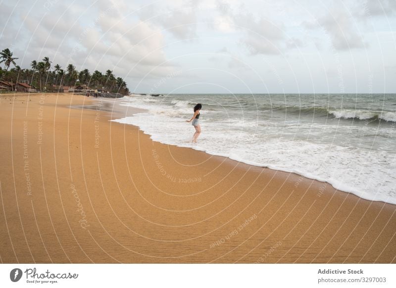 Anonyme friedliche Frau an einsamer Küste Tourismus Meeresufer reisen Strand laufen leer Sand erkunden Ansicht Himmel Cloud winken negombo Sri Lanka Küstenlinie
