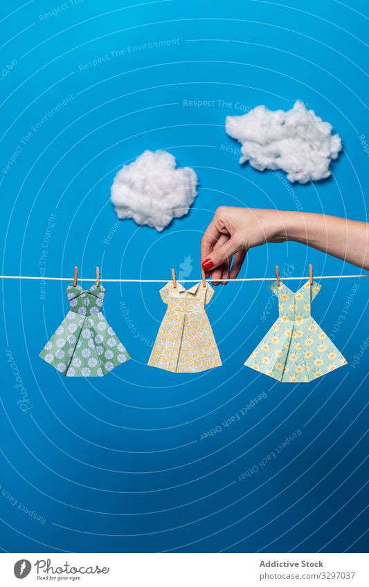 Nutzpflanzenfrau befestigt Origami-Kleider am Seil Frau Konzept befestigen hängen Sauberkeit Wäscherei Himmel Cloud hell lebhaft pulsierend Papier Attrappe