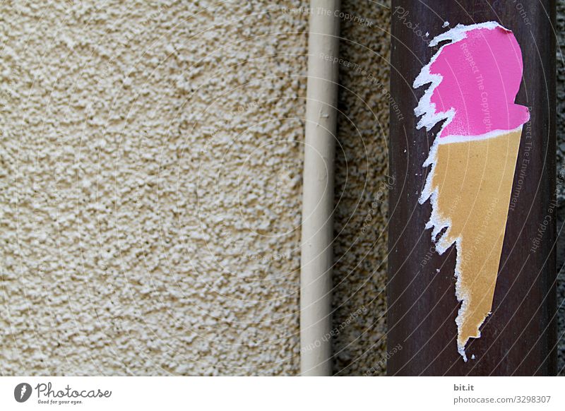 Lustiger, selbstgemachter Aufkleber in Form von Eis mit Eiskugel in pink und Eiswaffel, klebt kunstvoll, als Aufkleber aus Papier, an einer Regenrinne an beiger Wand aus Stein, in der Stadt und lädt zum Eisessen ein.