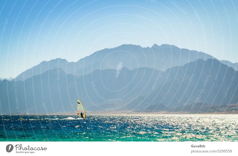 Surfer reitet in Ägypten ins Meer Dahab Erholung Ferien & Urlaub & Reisen Tourismus Insel Wellen Berge u. Gebirge Sport Natur Landschaft Wind Felsen Küste Segel