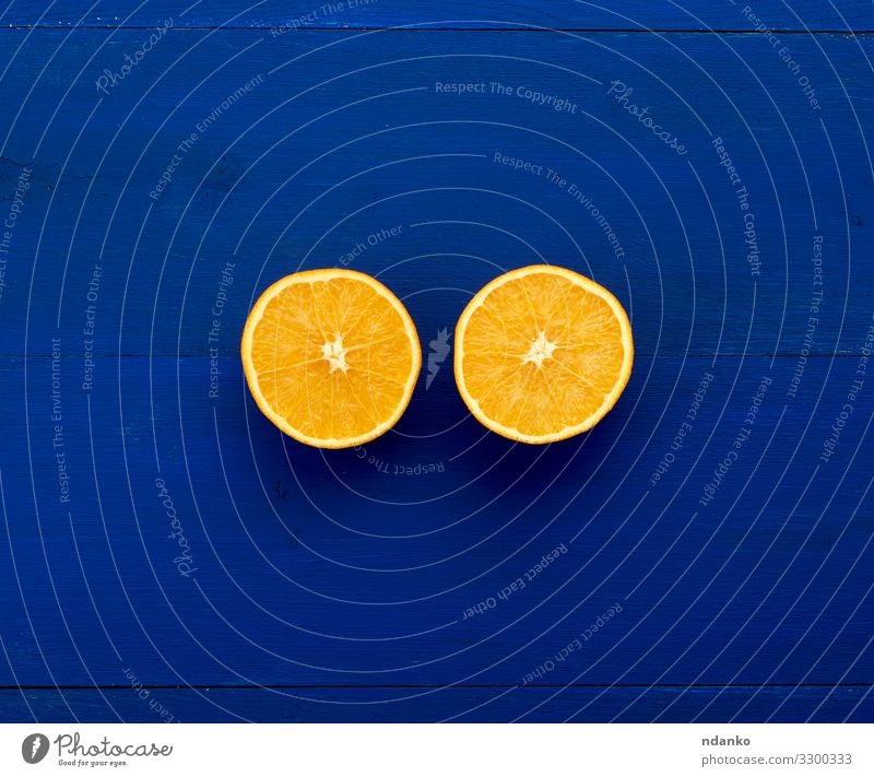 zwei Hälften einer orangefarbenen Rundorange Frucht Dessert Ernährung Vegetarische Ernährung Diät Saft Natur Holz frisch klein natürlich saftig blau Farbe