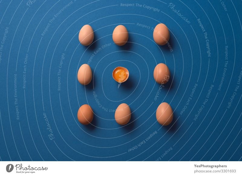 Ganze Eier und ein geknacktes Eigelb. Bio-Braune Eier Ernährung Diät Gesunde Ernährung frisch natürlich obere Ansicht ausgerichtet Blauer Hintergrund