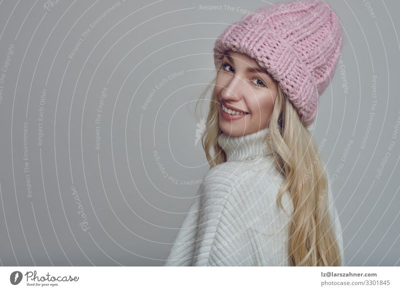 Lächelnde junge Frau mit rosa gestrickter Wintermütze Glück schön Gesicht Erwachsene 1 Mensch 18-30 Jahre Jugendliche Wärme Wald Wege & Pfade Pullover Hut blond