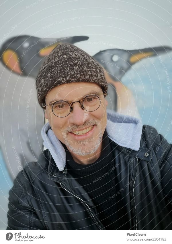 Mann mit Mütze vor einer Graffitiwand human Person Porträit Pinguin urban Großstadt Bart Gesicht Kaputze